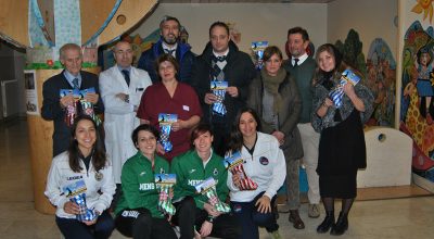 Gli atleti e i dirigenti della Polisportiva Mens Sana 1871 consegnano le calze della Befana, donate dal supermercato Pam, ai piccoli pazienti del Dipartimento Materno Infantile delle Scotte