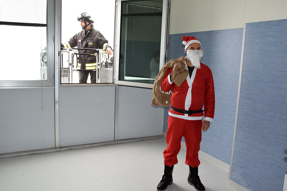 Il Babbo Natale dei Vigili del Fuoco raggiunge con l’autoscala i piani alti dell’ospedale e porta i doni ai piccoli pazienti dell’Aou Senese